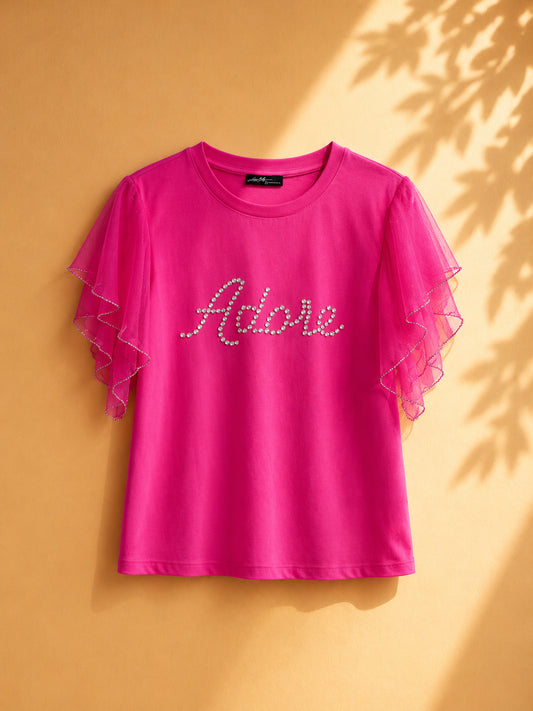 CAMISA FUCSIA DE MANGAS DE TELA PUNTO CON LETRAS ADORE EN ACESSORIOS PLATEADOS