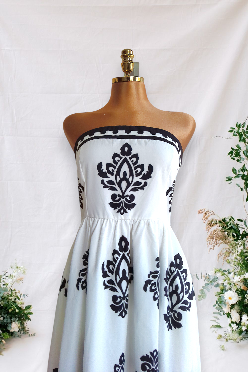 VESTIDO ESCOTADO BLANCO CON ESTANPADO DE FIGURAS NEGRAS